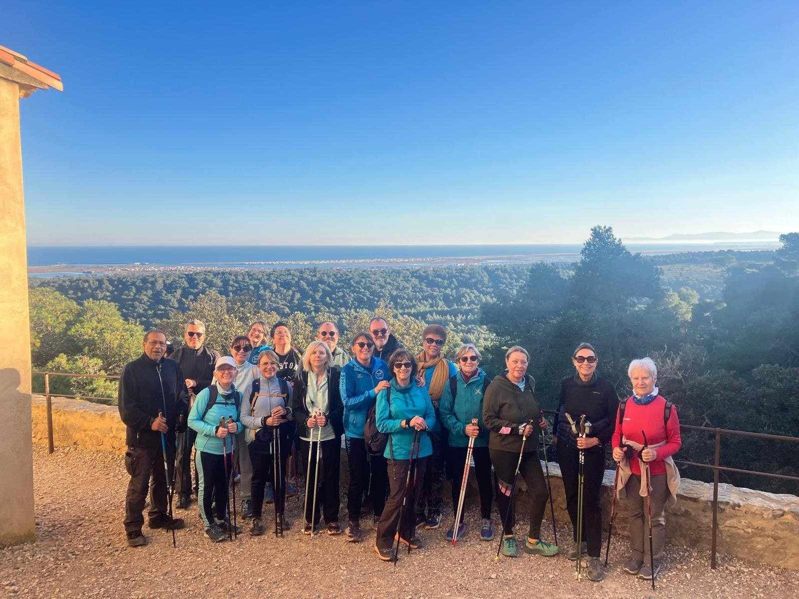 Groupe de marche nordique du club devant le panorama de la mer et des étangs